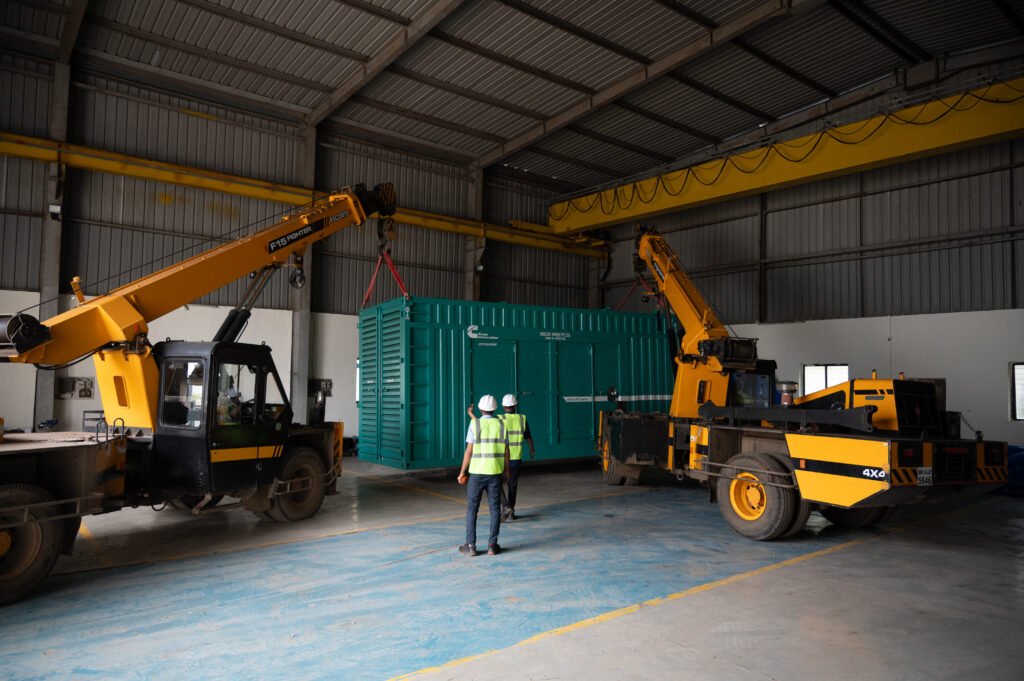 Two cranes lifting a shipping container