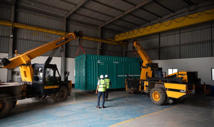 Two cranes lifting a shipping container