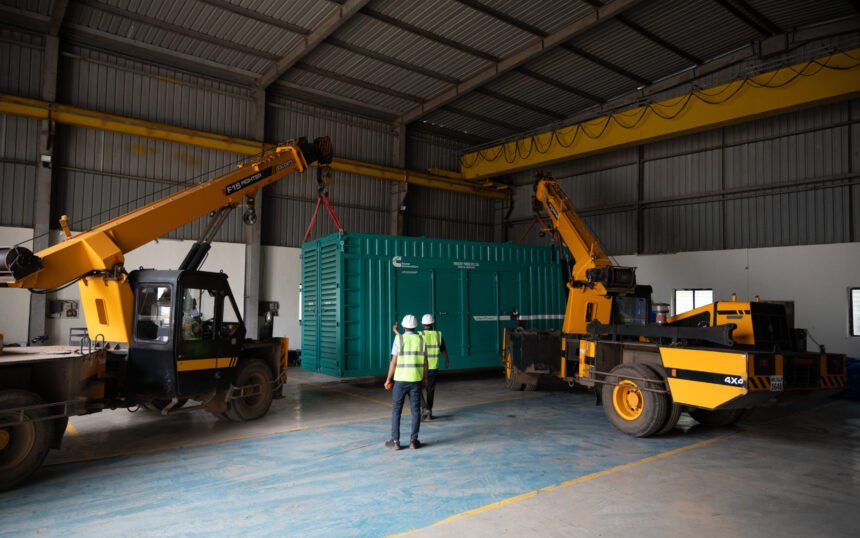 Two cranes lifting a shipping container